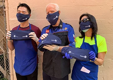Three volunteers wearing Rotary-branded clothing.